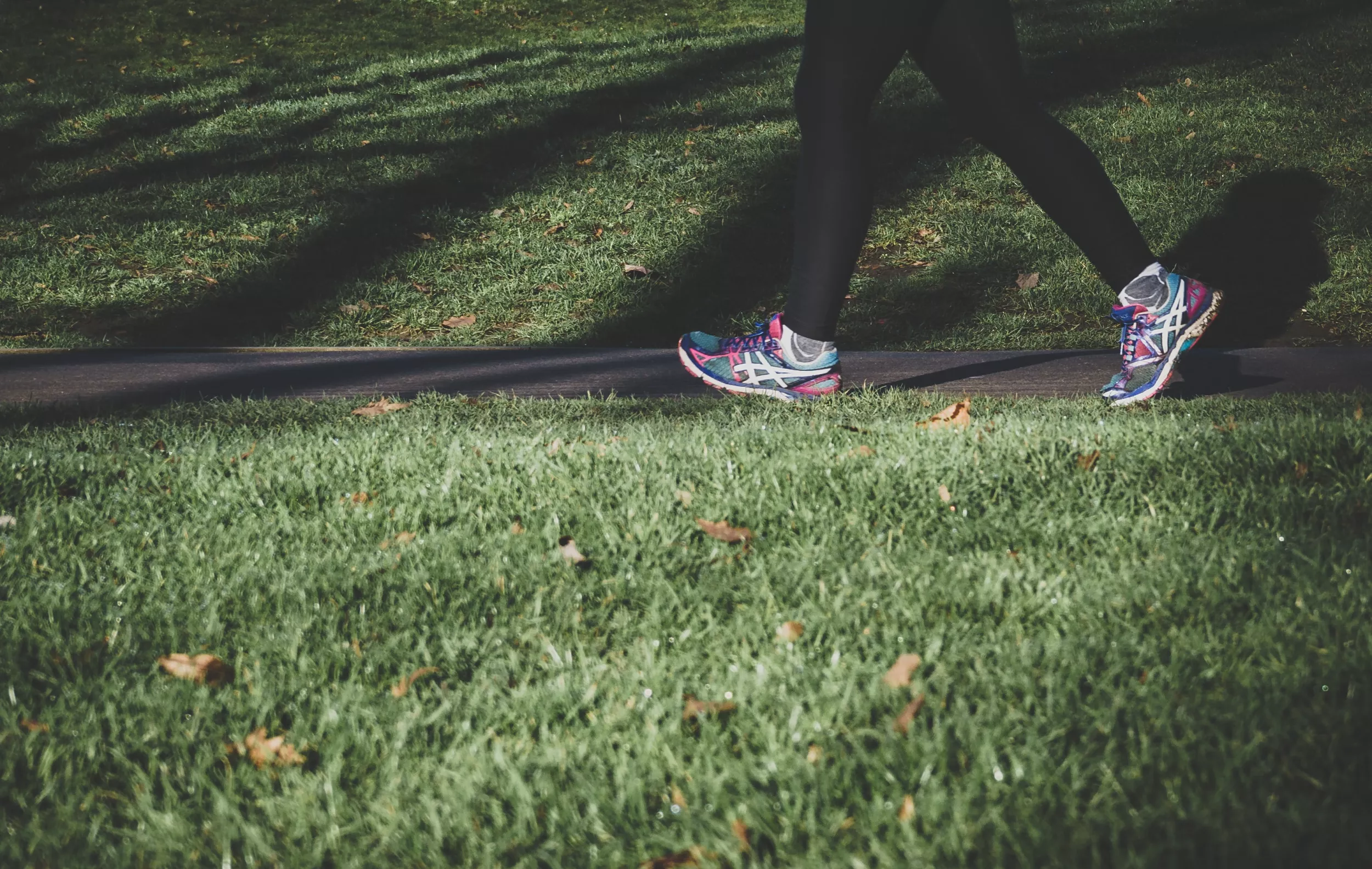 Image of someone's feet and legs on a grass path