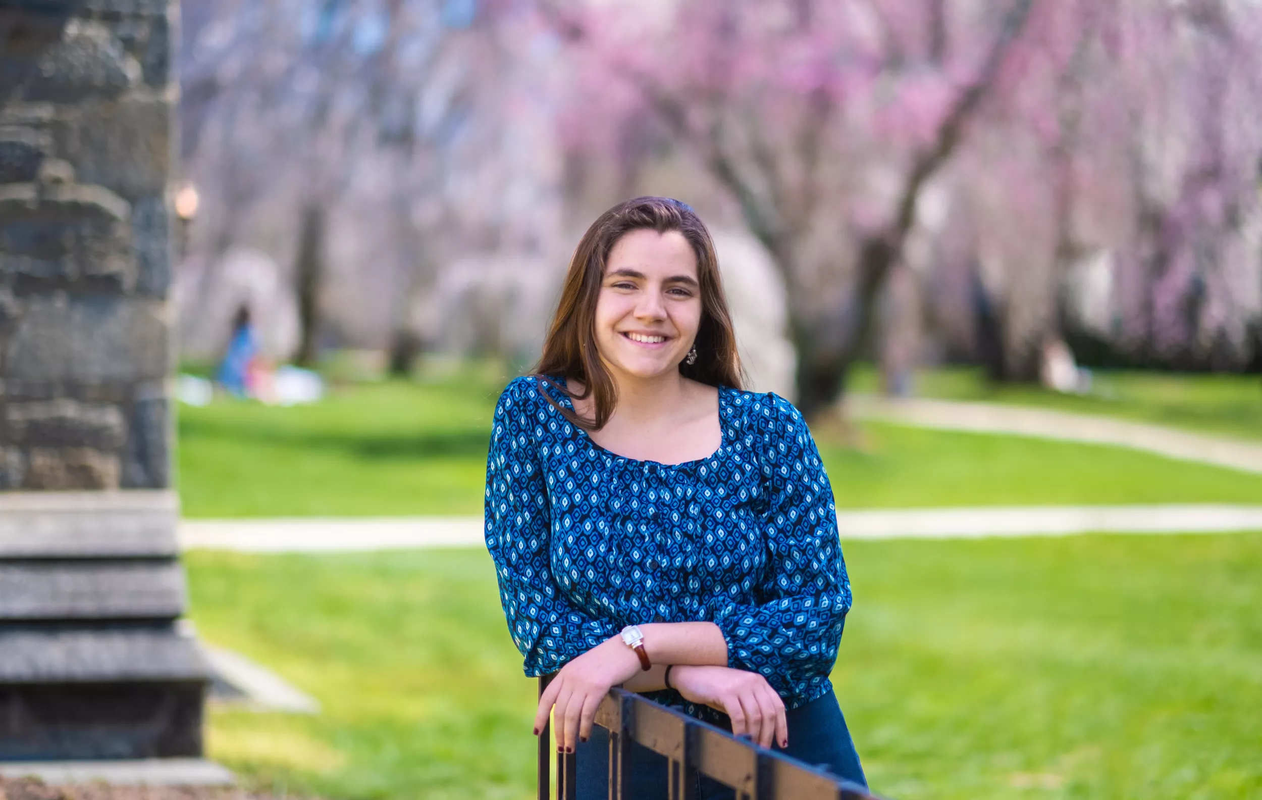 Charlotte McDermott posing with cherry blossoms in the background