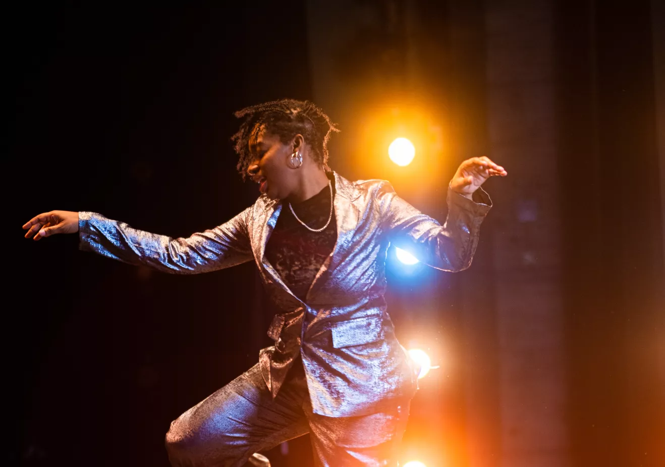 Lela Aisha Jones dancing in front of stage lights