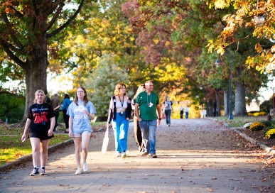 A small group of people walks towards the camera on Taylor Drive