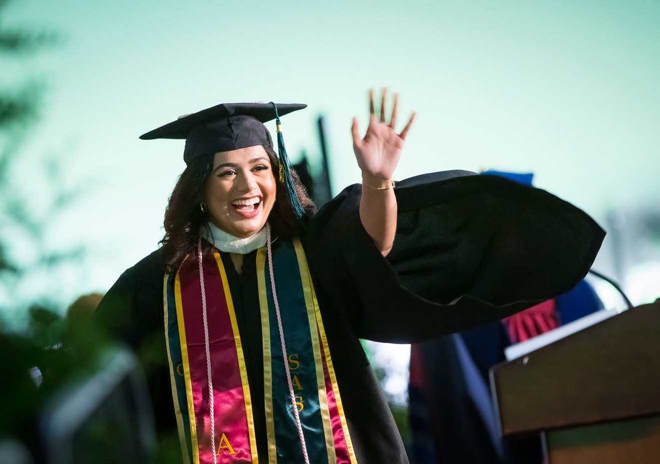 Graduate waving during Commencement