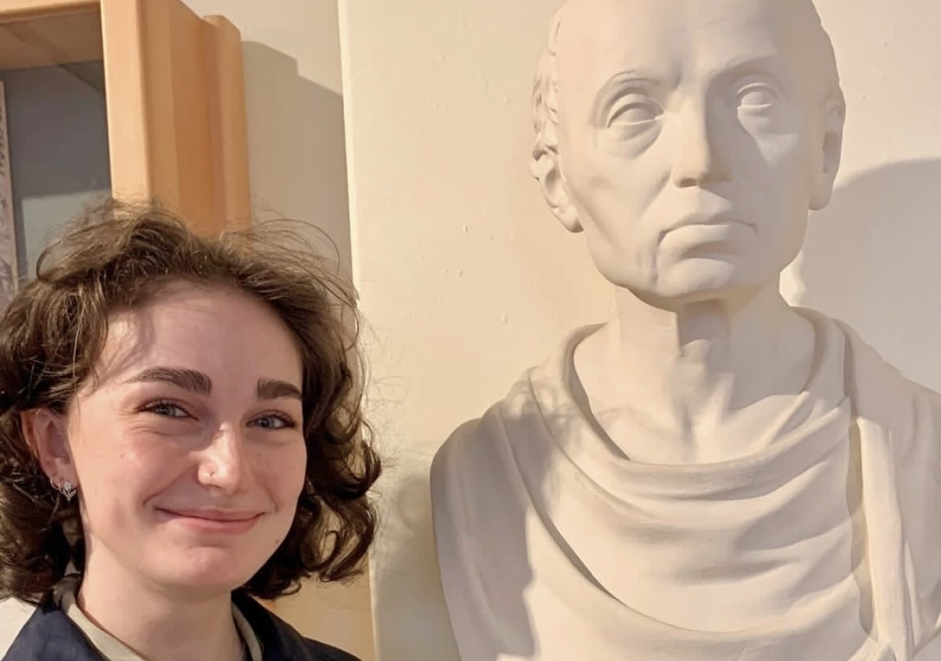 Emily Shein posing with a bust of Immanuel Kant