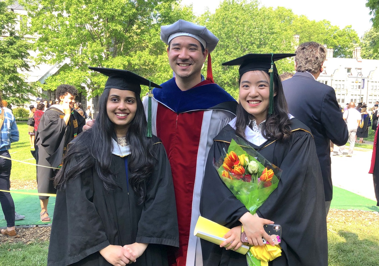 Two graduates with a faculty member