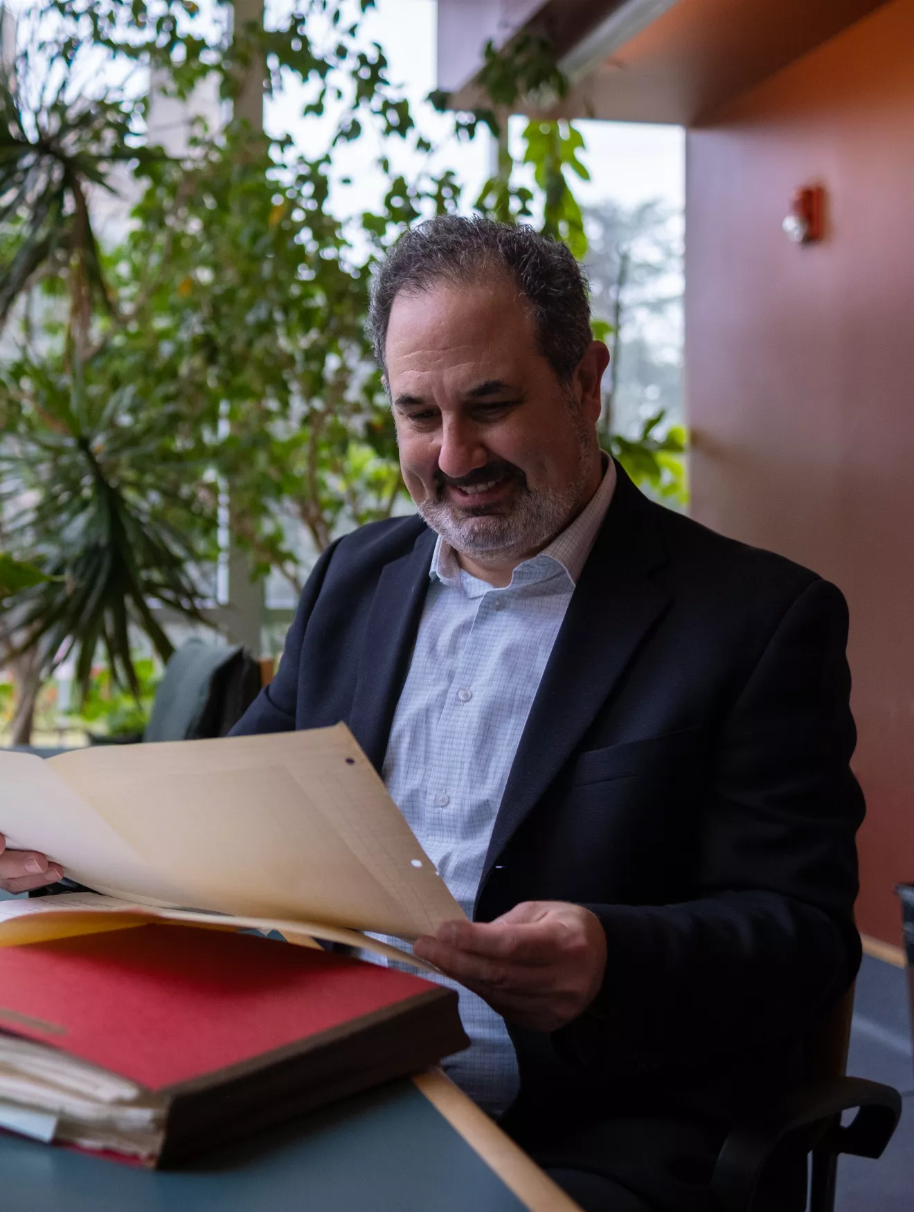 Marc Schulz smiling as he looks down at his files