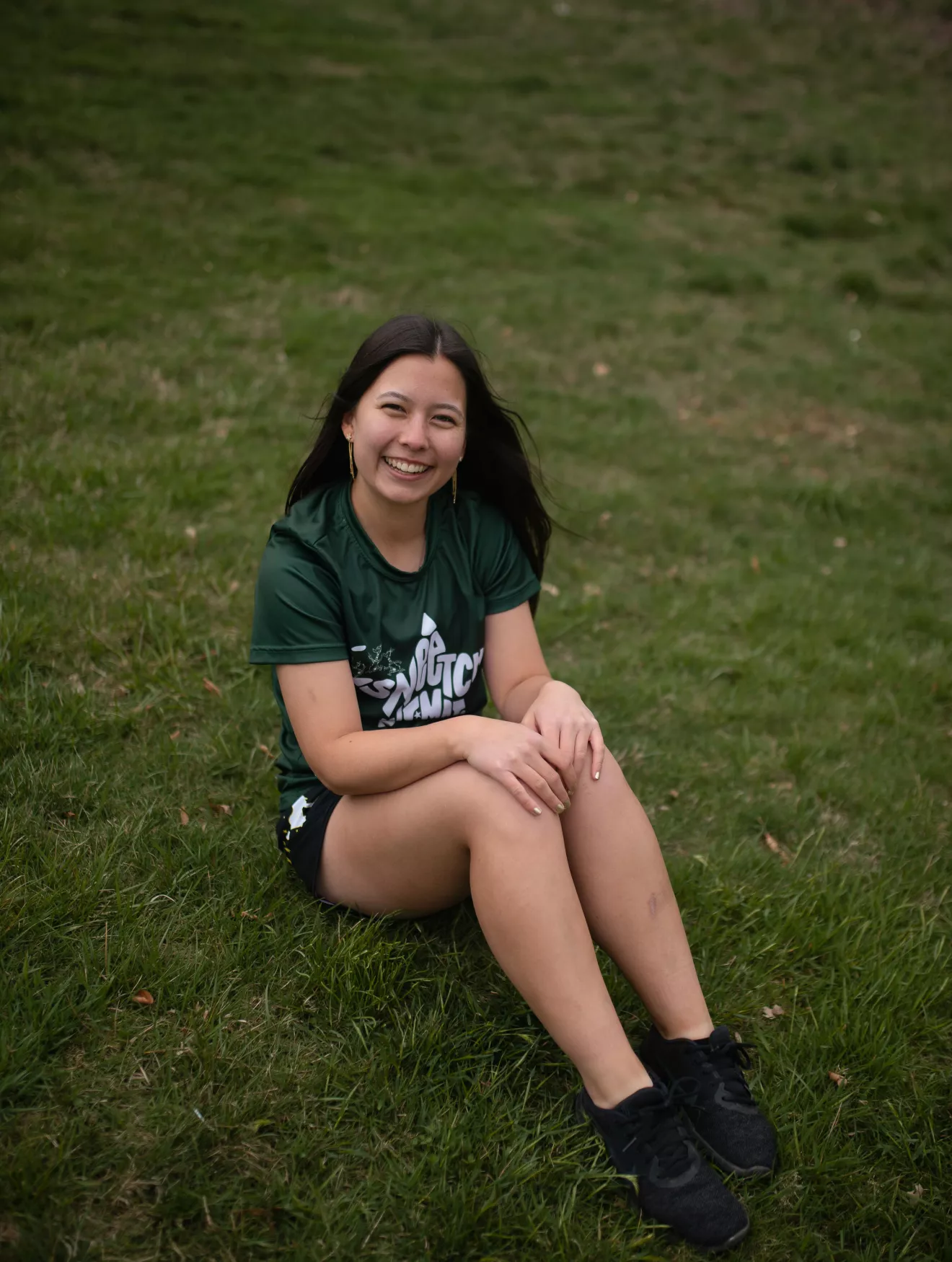 Amy Tse sitting on a field. 