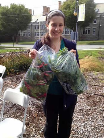 Image of student volunteer with bags of chard and kale