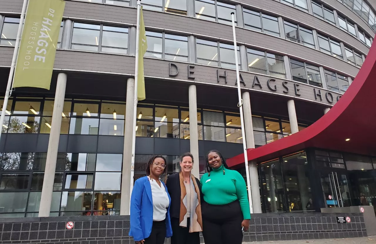 Alison Cook-Sahter, Khadijah Seay, and Ebony Graham standing in front of the Hague University in The Netherlands