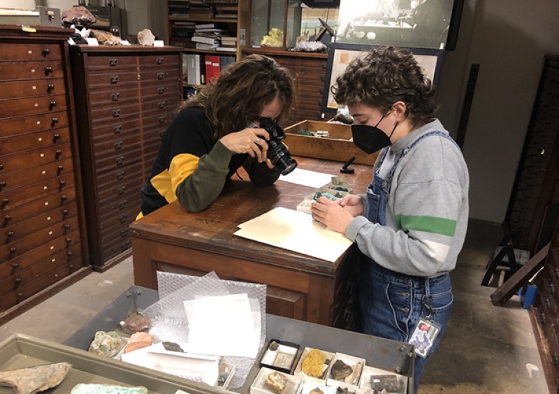 Artist and student look at empty boxes that remain from the uranium once stored in the collection.