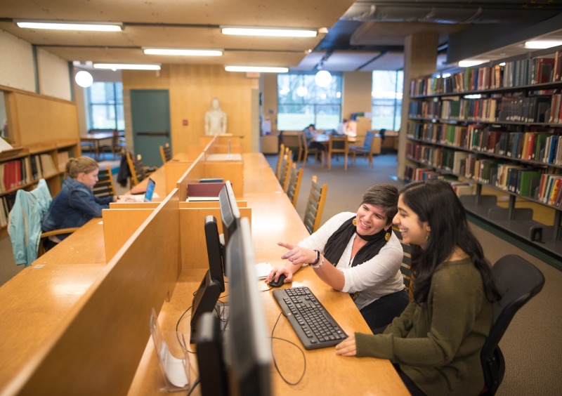 Two students looking at a computer monitor