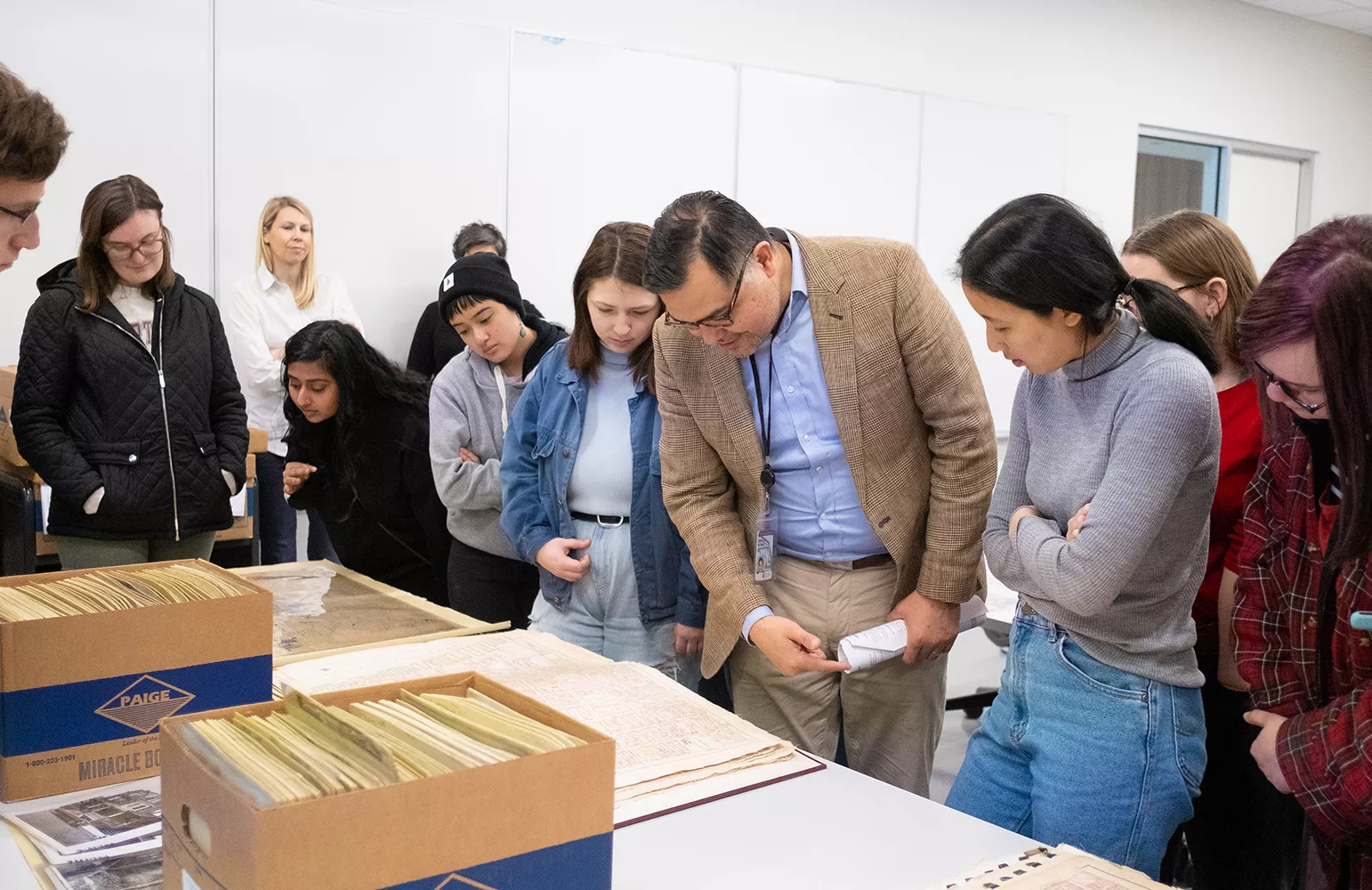 Students in 'The Philadelphia Mosaic' view material from Temple University's Urban Archives with Librarian 