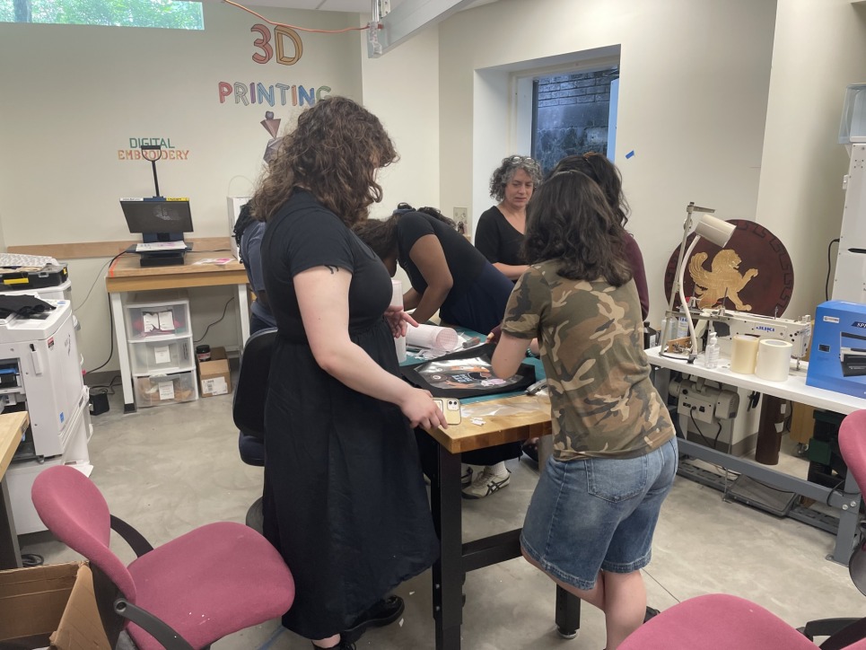 The Digital Technology Interns work with Bronwen Densmore, Makerspace Coordinator, on an introductory project for the program, creating a group tote bag 