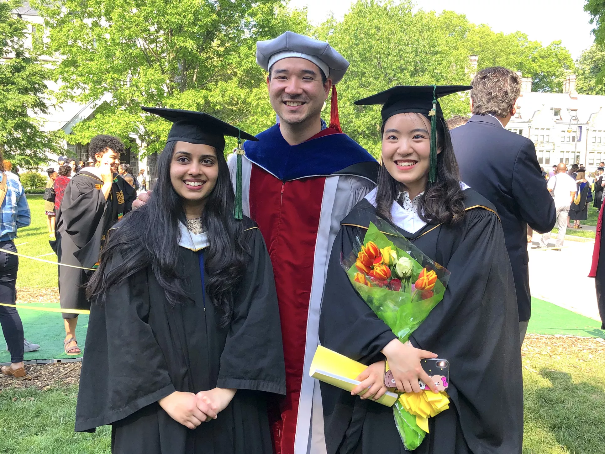 Two graduates with a faculty member