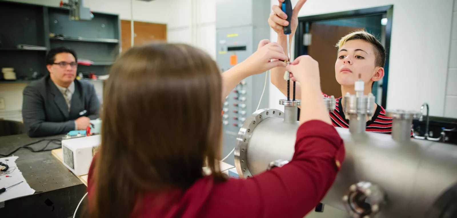 Physics professor and students working in a lab.