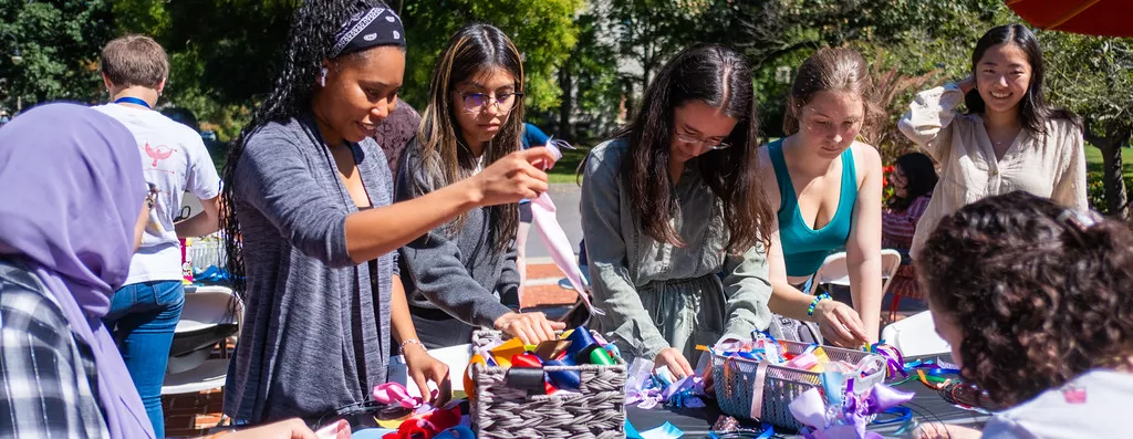 Community members use ribbons to create a wreath craft.