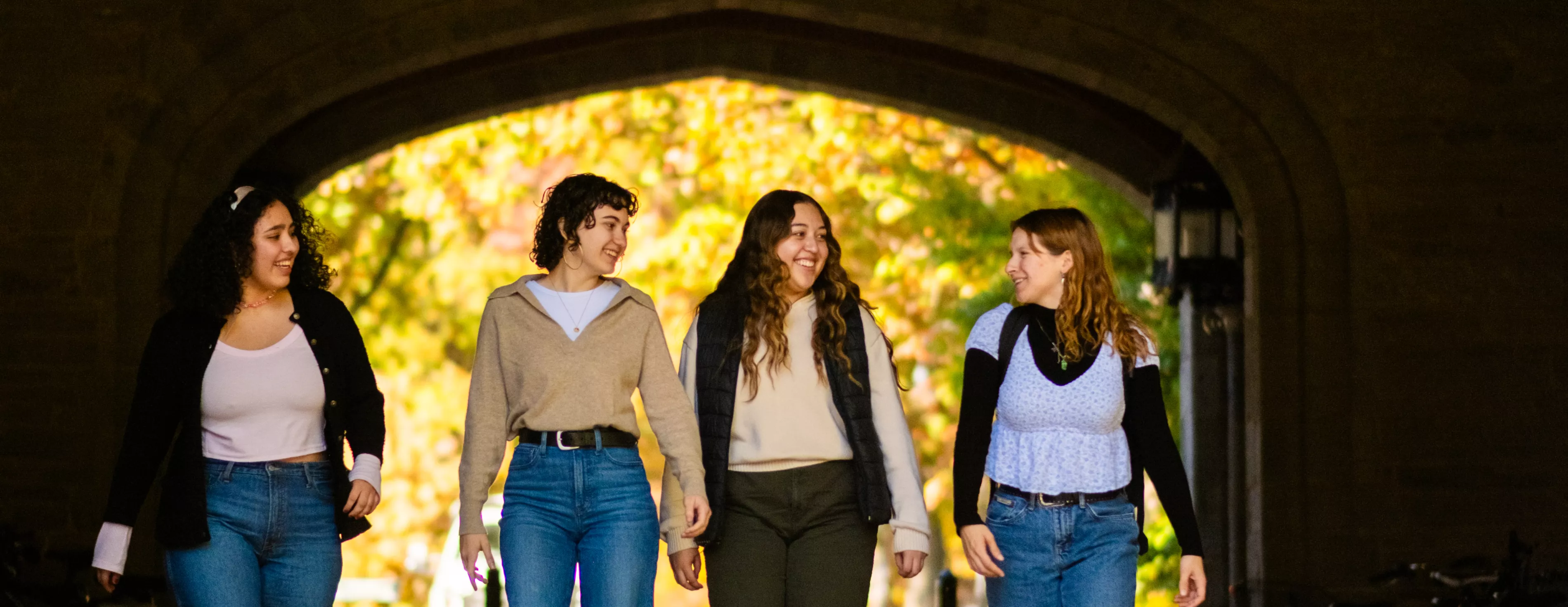 four students walking through Pembroke Arch