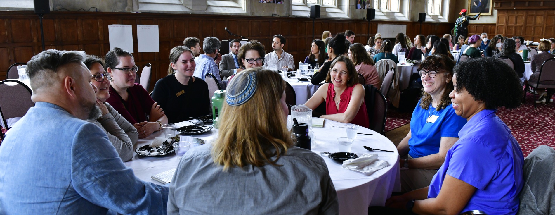 People seated around tables at a large luncheon. 