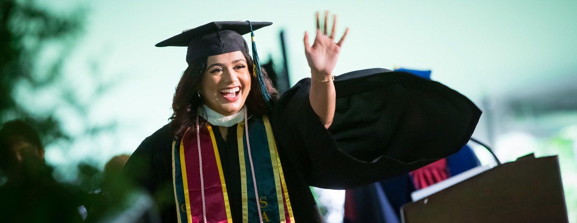 Graduate waving during Commencement