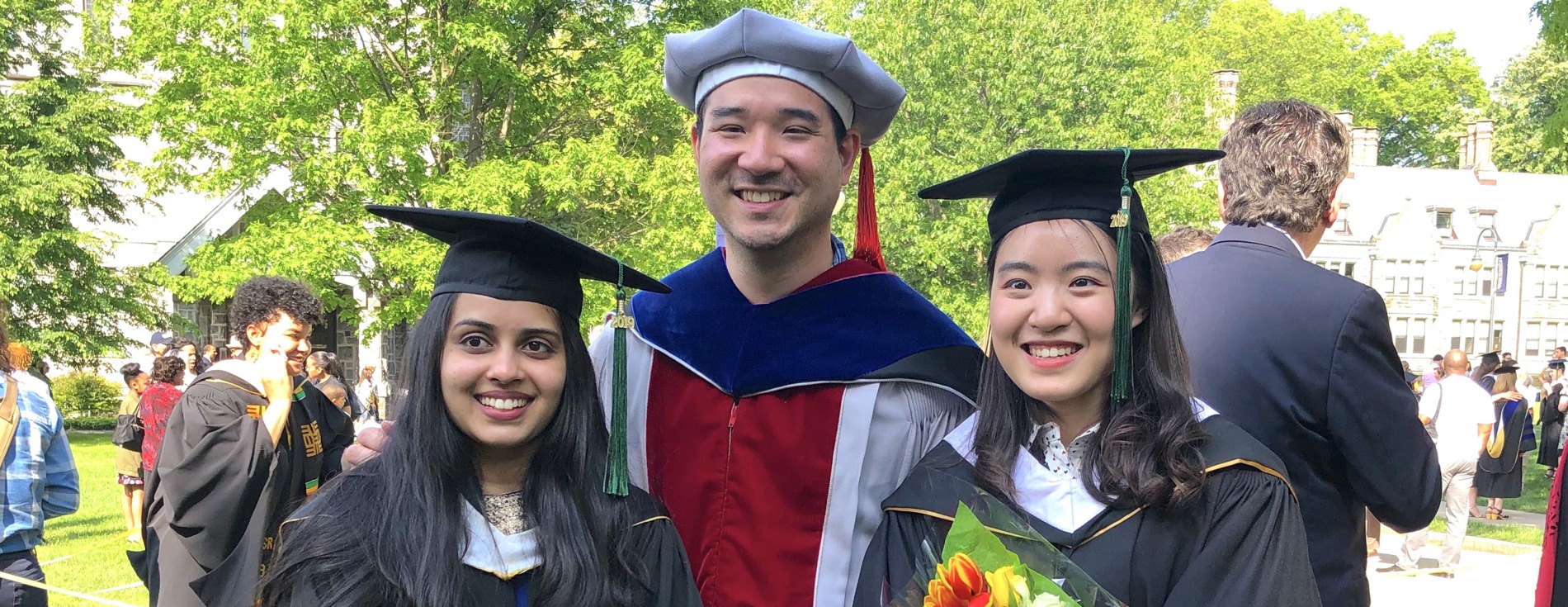 Two graduates with a faculty member