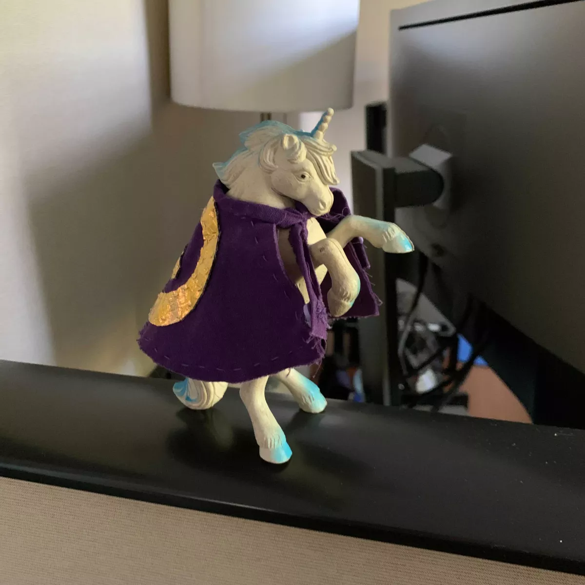 A toy unicorn wearing a cape