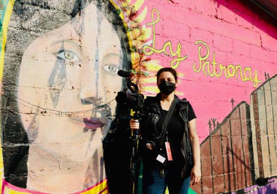 Tania Romero at Las Patronas, in front of a wall mural
