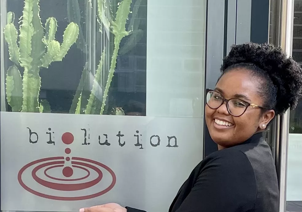 Whitney smiling next to a biolution sign