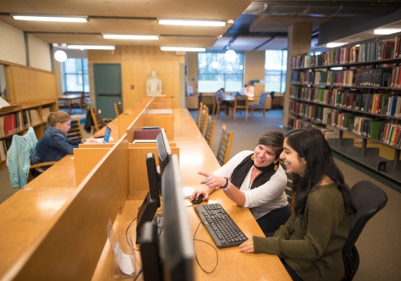 Two students looking at a computer monitor