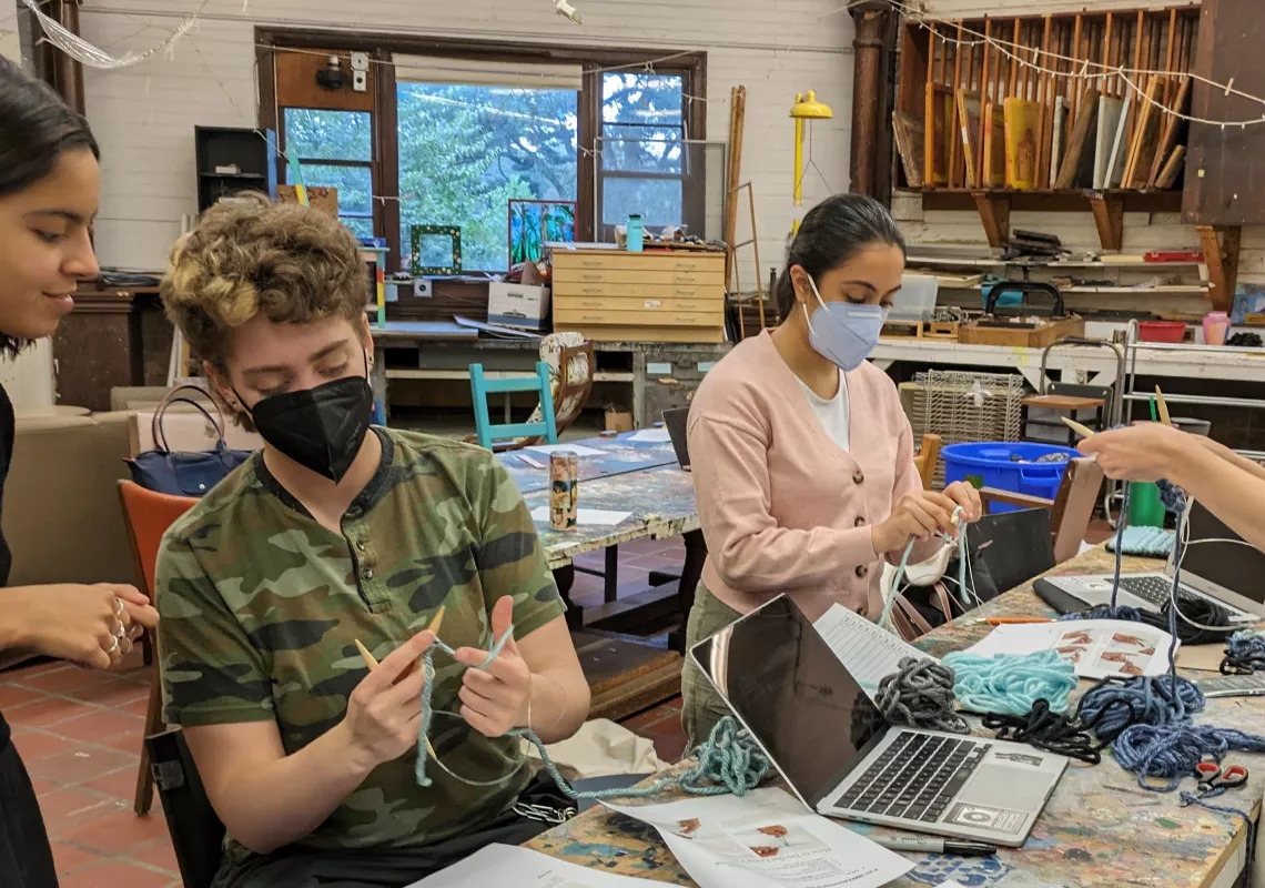 Students work on tapestries representing sulfur dioxide emissions from coal-fired power plants