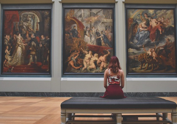 Woman looking at paintings in museum