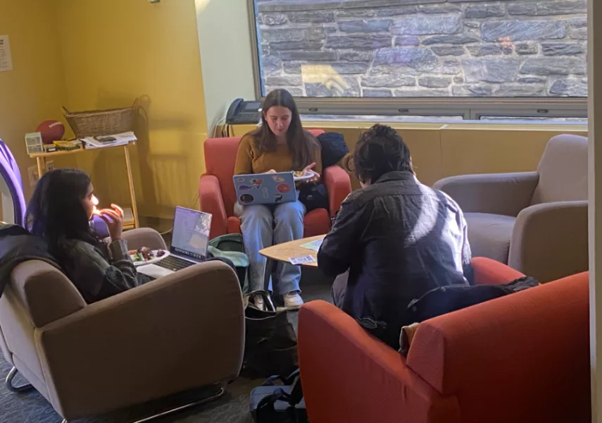 Students sit on their laptops in a circle