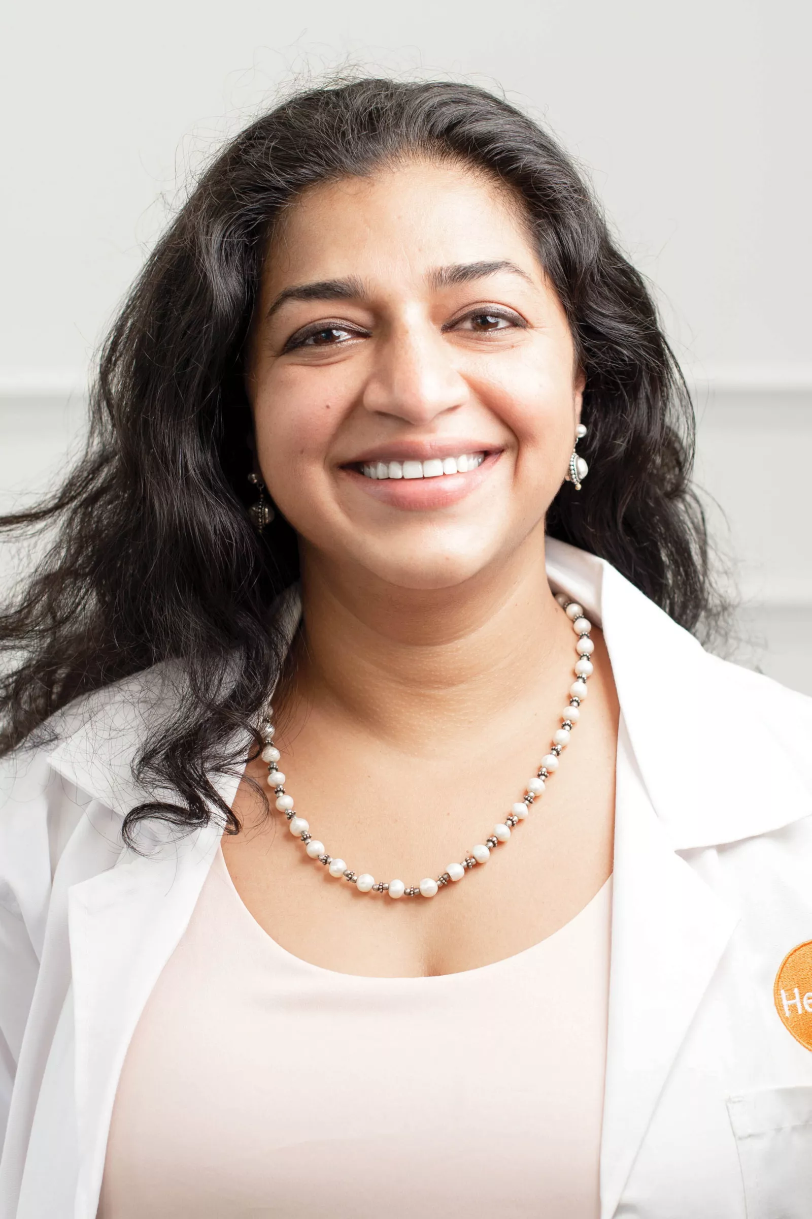 Close up portrait of Radha Karnad in a lab coat