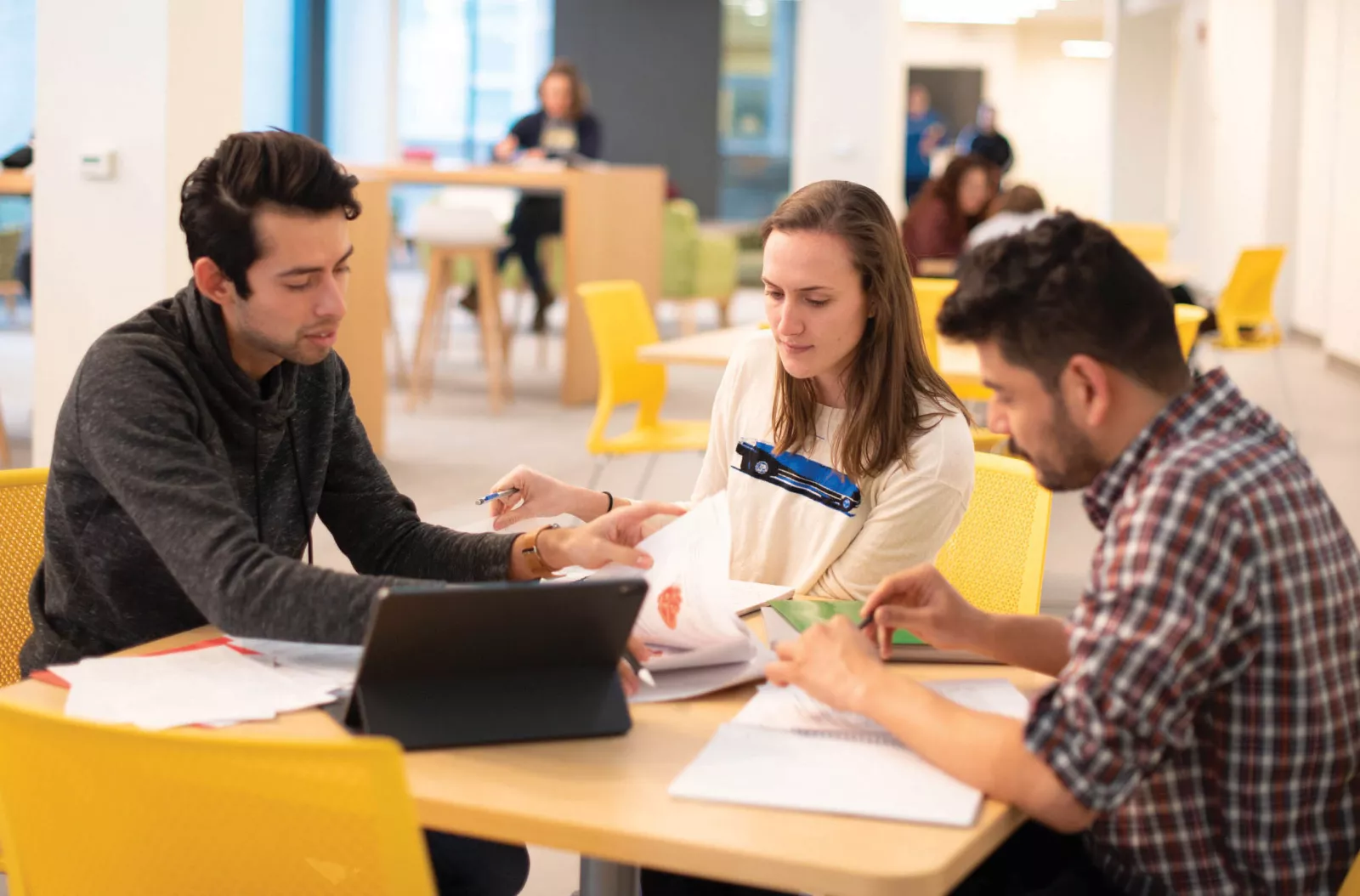 Three students sitting around a table studying