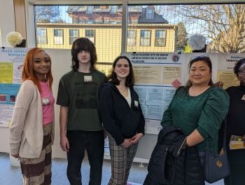 Students with community mentor at the Praxis poster session