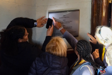 Students and parents pointing at sign in old library