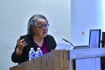 Barbara Savage speaking at a podium