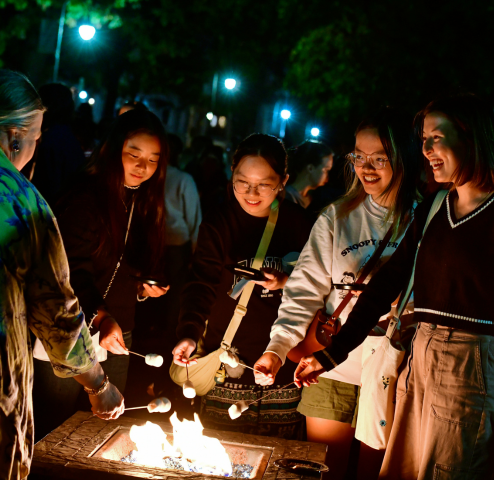 Students roasting smores over a fire