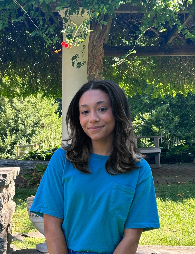 Girl wearing a blue shirt and smiling.