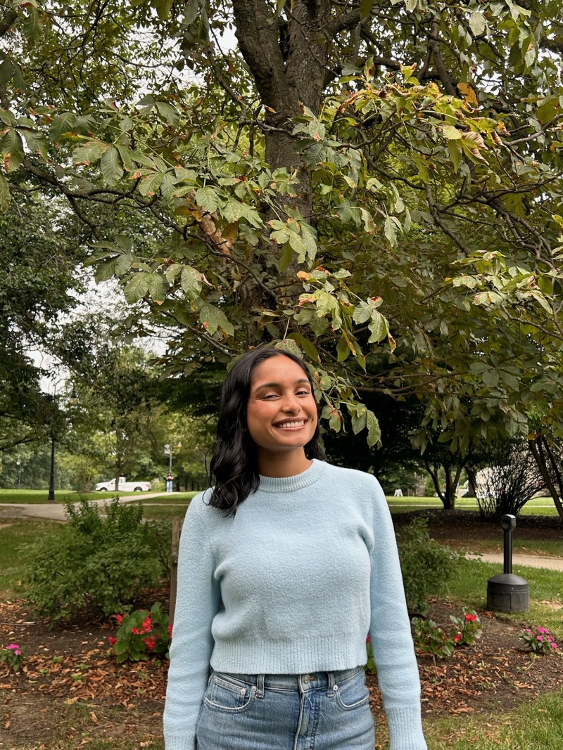 Girl wearing a blue sweater and smiling.