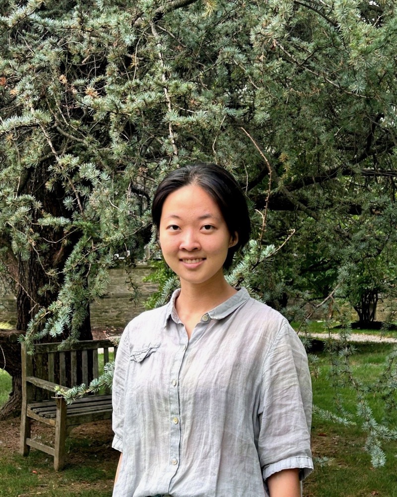 Girl wearing a button up shirt and smiling.