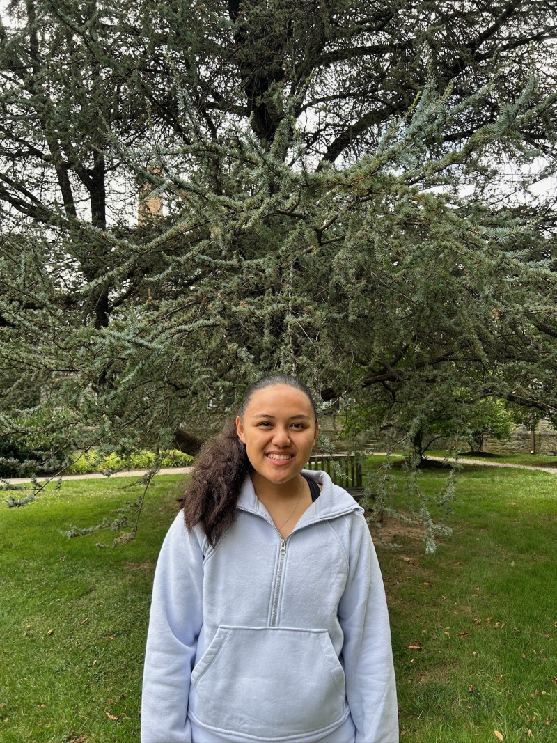 Girl wearing a blue sweatshirt and smiling.