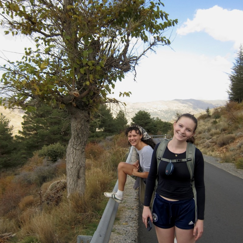 Charlotte Oehly and friend pose on a hike with a mountain in the background