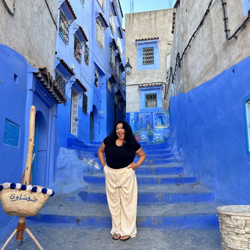 Jackie standing in at the bottom of a bright blue staircase