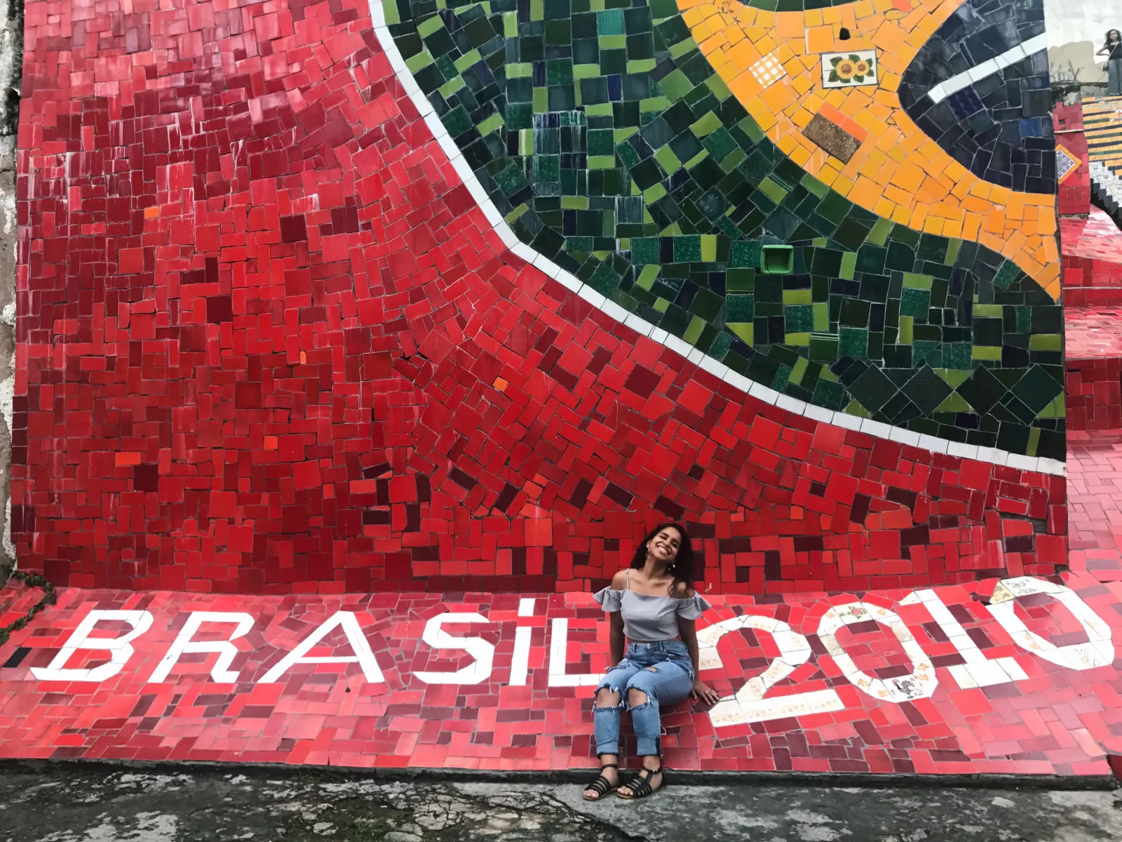 Paola sitting on mosaic tile art in Brazil