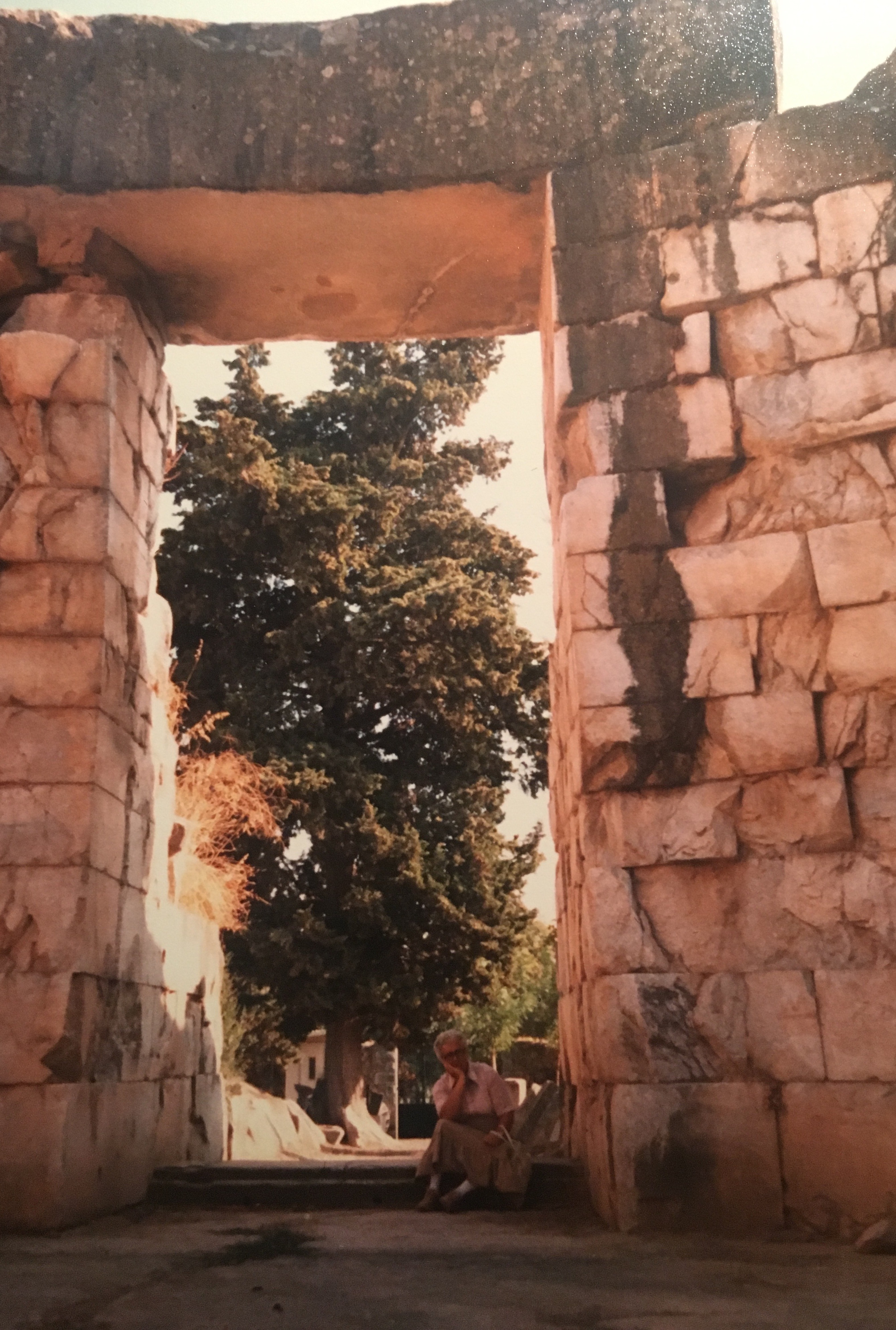 Woman sitting in doorway of ancient tomb